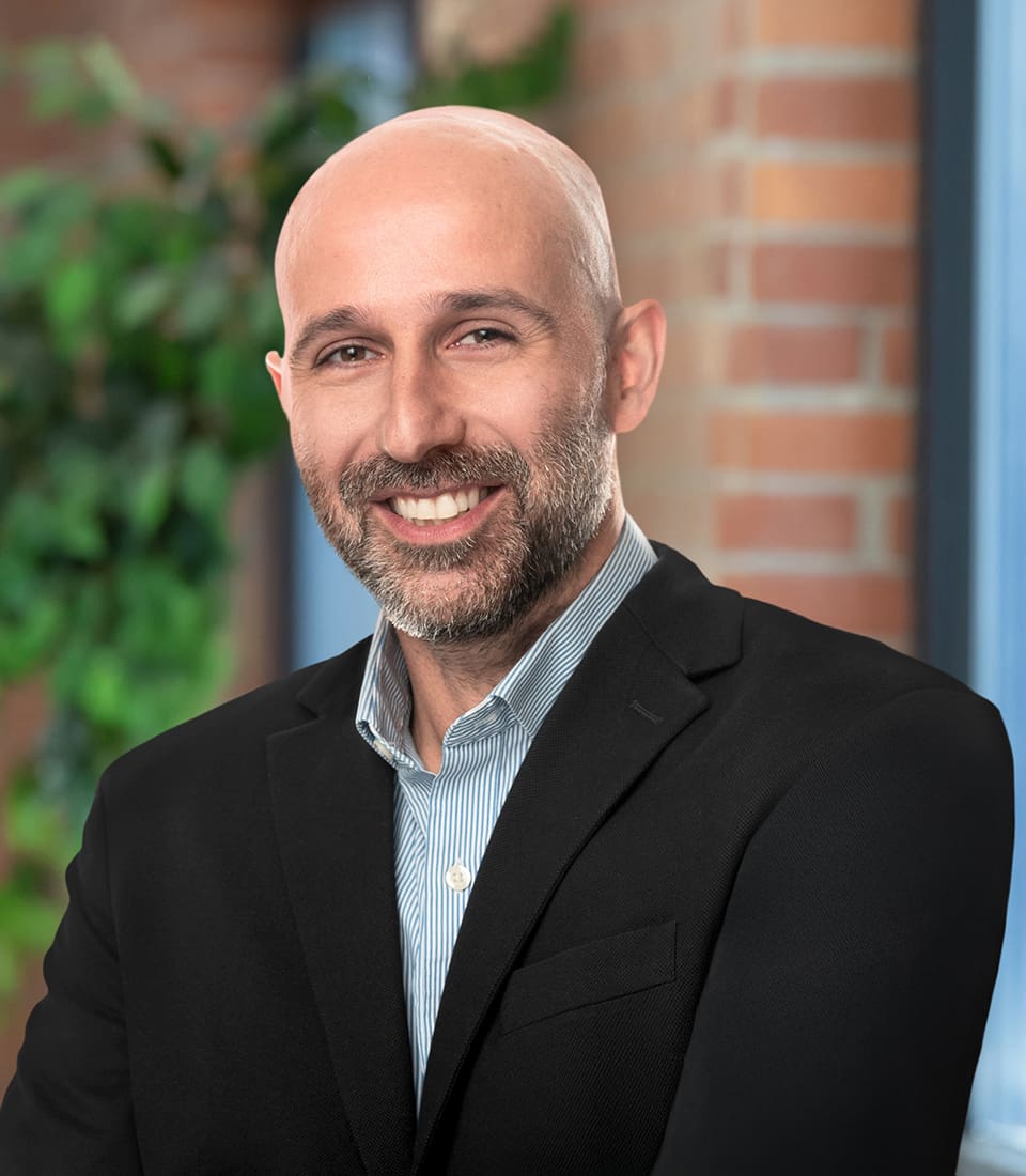 A professional headshot of Bernardo Escudero