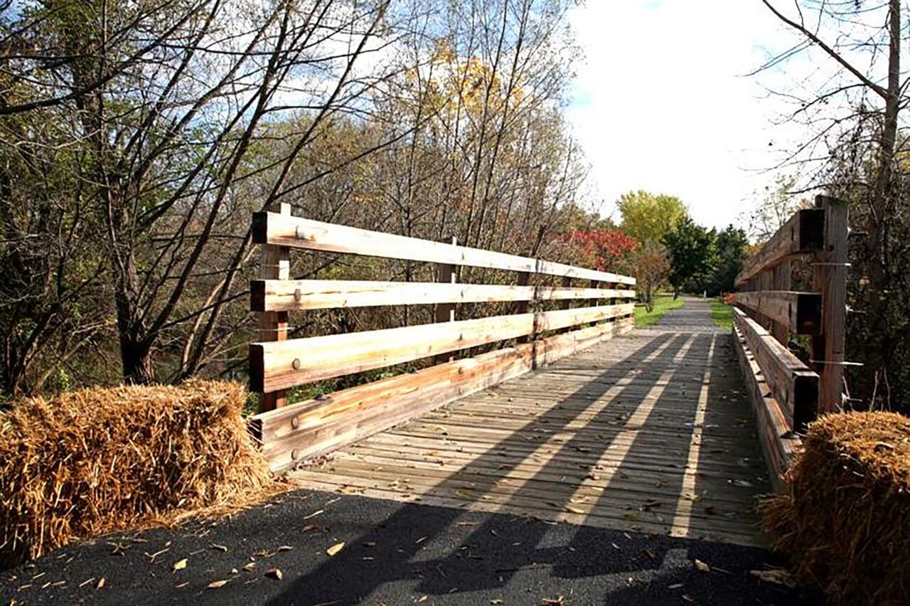 A photograph of a pedestrian bridge crossing along a rail trail