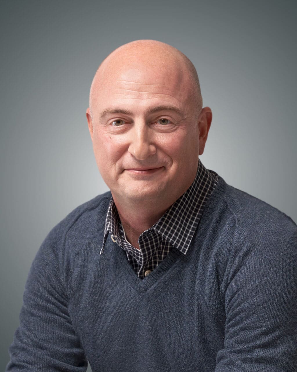 A professional headshot of Ryan Barr on a grey and white gradient background.