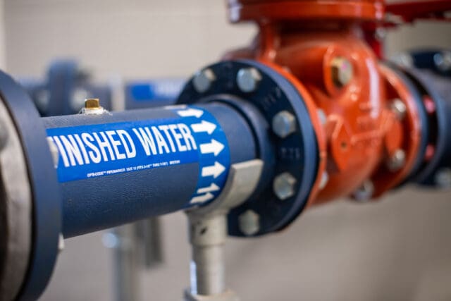 A photograph of red and blue pipes with a label that says Finished Water