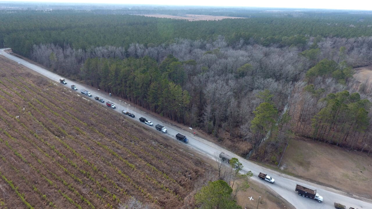 An aerial photograph of a road with trucks lined up