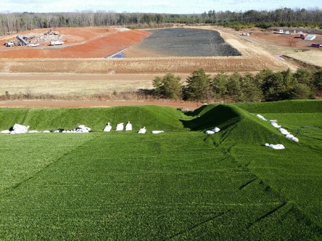 A photograph of artificial turf over a landfill