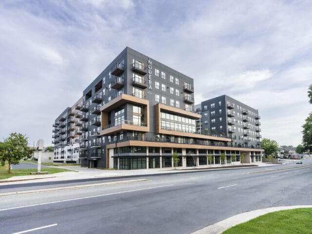 An exterior photograph of Modera LoSo, a multi-story apartment complex