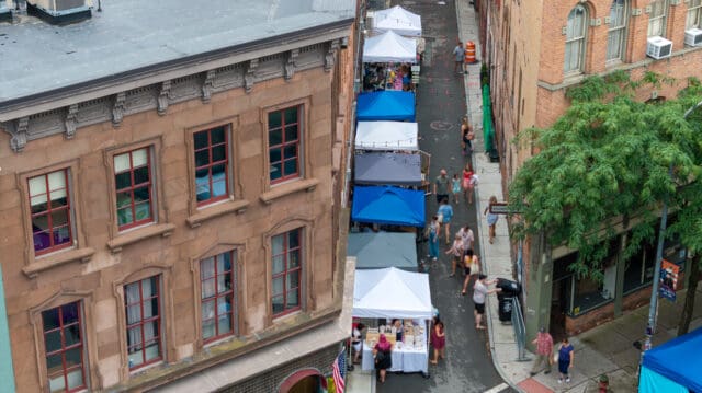 An aerial photograph of people milling about during a farmers' market in Franklin Alley in Troy, NY