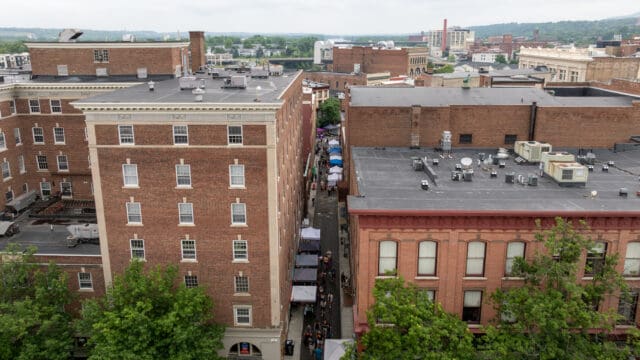 An aerial photograph of people milling about during a farmers' market in Franklin Alley in Troy, NY