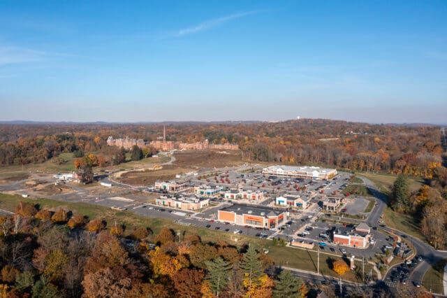 An aerial photograph of the Hudson Heritage plaza including remains of the former Hudson River Psychiatric Center in the background