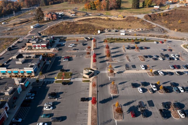 An aerial photograph of a parking lot, sidewalks, and room for development on the Hudson Heritage property