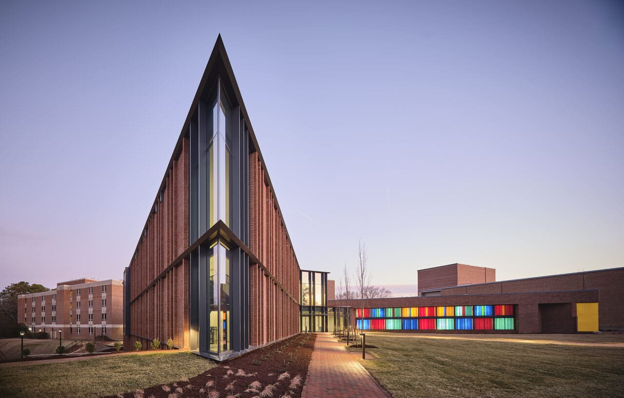 A photograph of a dramatically angular building with colorful glass windows.