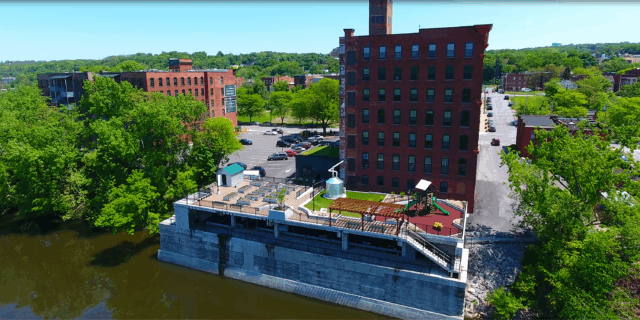 A photograph of an elevated park behind a building occupied by affordable housing units