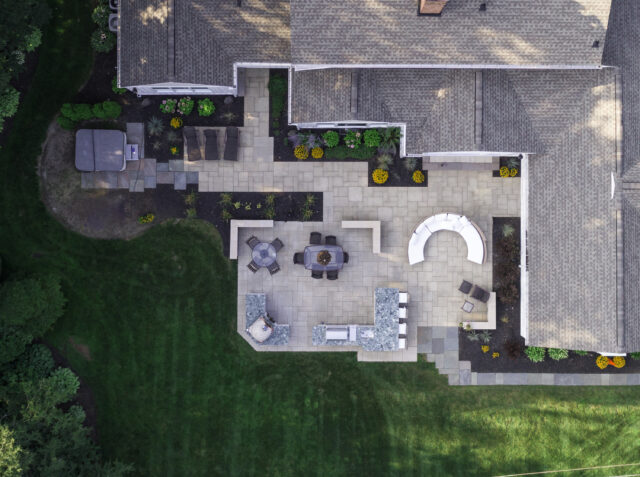 An aerial photograph of a designed backyard patio with seating areas and plantings