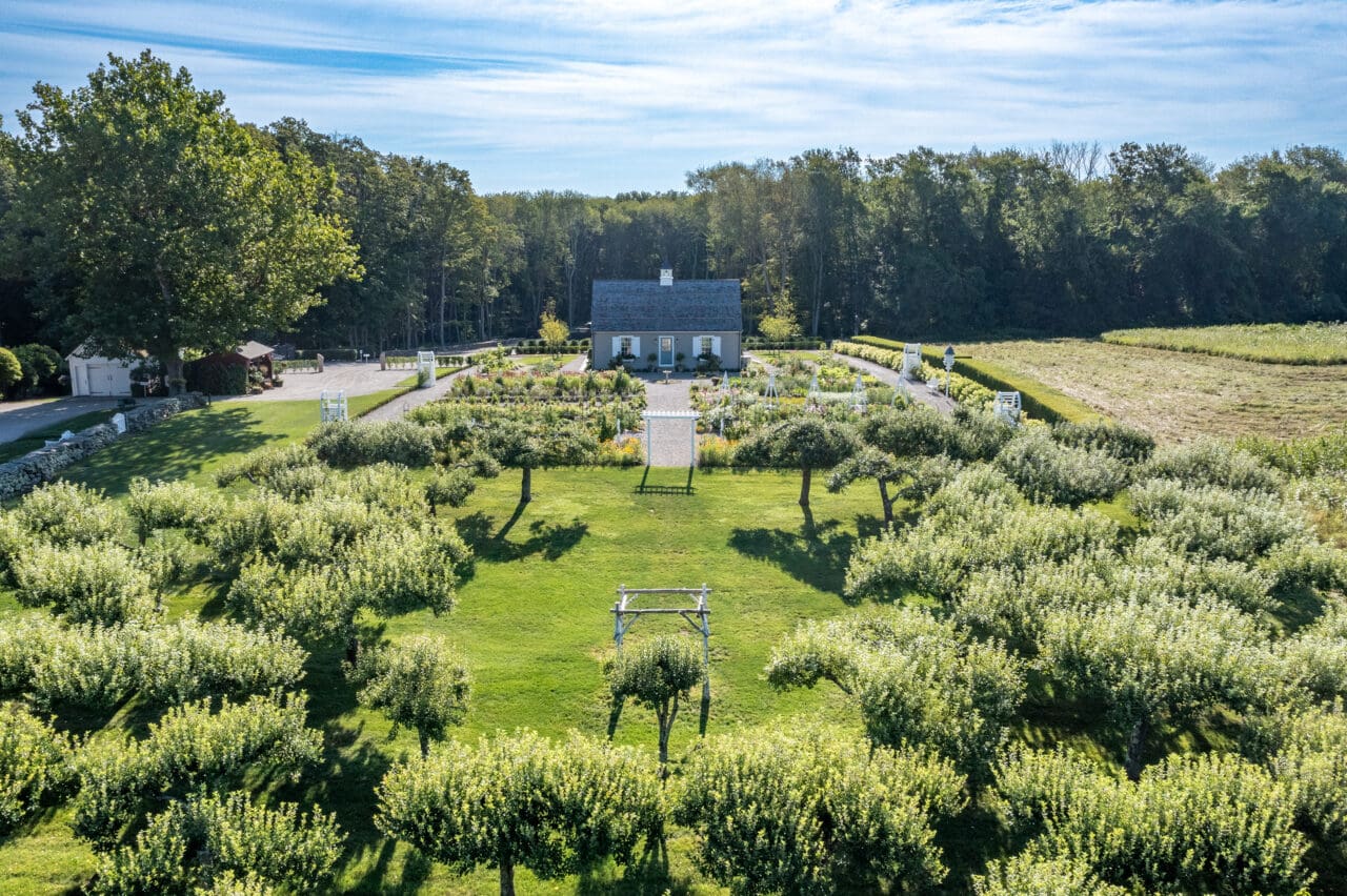 An aerial photograph of an apple orchard with a clearing at the center, multiple arbors, and a cottage at Smith Farm Gardens venue in East Haddam, CT