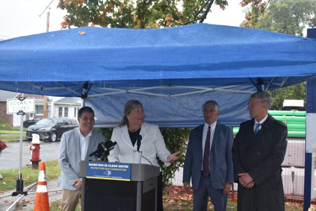A photograph of New York State Environmental Facilities Corporation President and CEO Maureen Colemand speaking at a podium under a tent in front of four other people