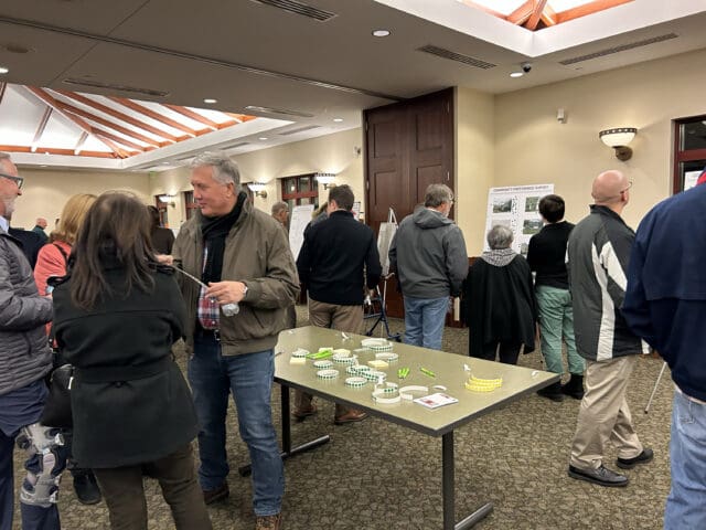 A photograph of people looking at boards on easels in Clay, NY