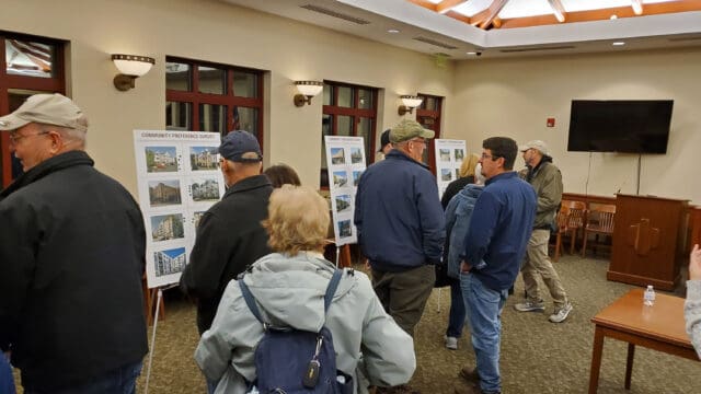A photograph of people looking at boards on easels in Clay, NY