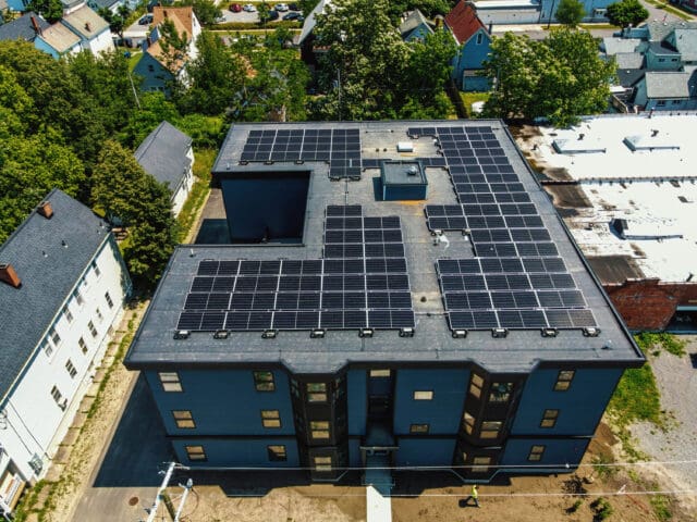 An aerial photograph of a building with solar panels on the roof