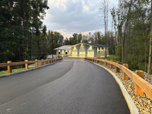 A photograph at dusk looking down a driveway toward a building