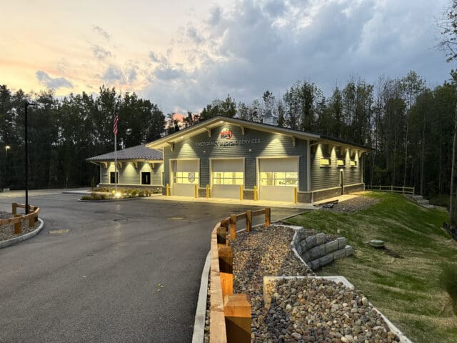 A photograph at dusk looking down a driveway toward a building