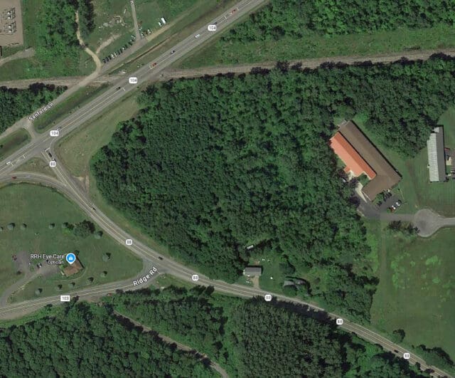 An aerial photograph of a forested area between two roads.