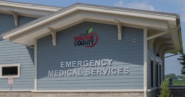 A photograph of exterior signage on a building with the Wayne County NY logo and the words Emergency Medical Services underneath.
