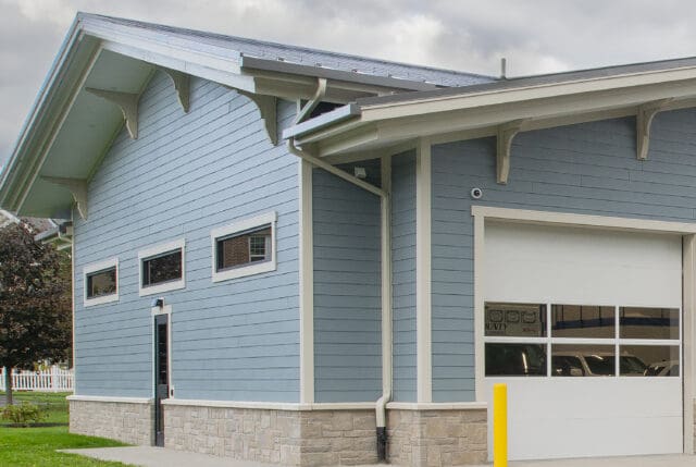 A photograph of a blue building highlighting Craftsman style architecture.