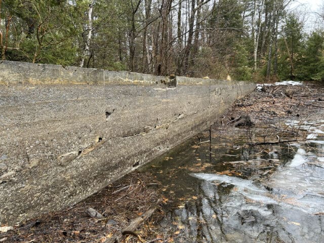 A photograph of a reservoir wall that shows evidence of very low water levels.