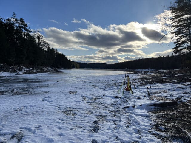 A photograph of survey equipment along the edge of a lake during winter