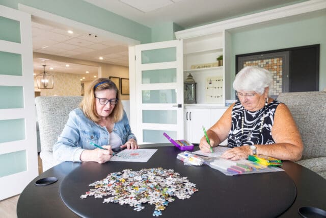 A photograph of two individuals doing arts and crafts at a table.