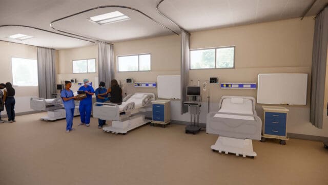 A simulation of a healthcare space. Medical staff are standing about the room. There are three hospital beds with curtains.