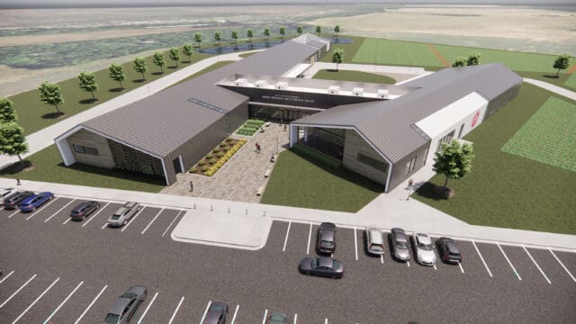 A simulation of a large building with courtyard and parking lot in an agricultural setting.