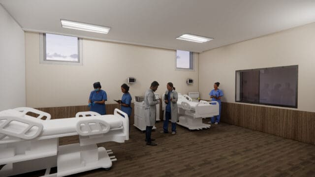 A simulation of a nursing school classroom with nurses and doctors standing around two hospital beds.