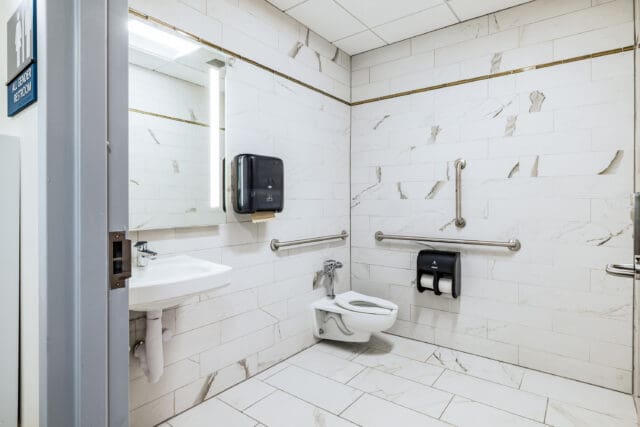 A photograph of a recently renovated restroom with all white materials
