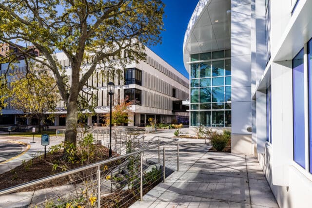 A photograph of the courtyard of the MUSC College of Pharmacy. Multiple railings line various pedestrian paths and staircases.