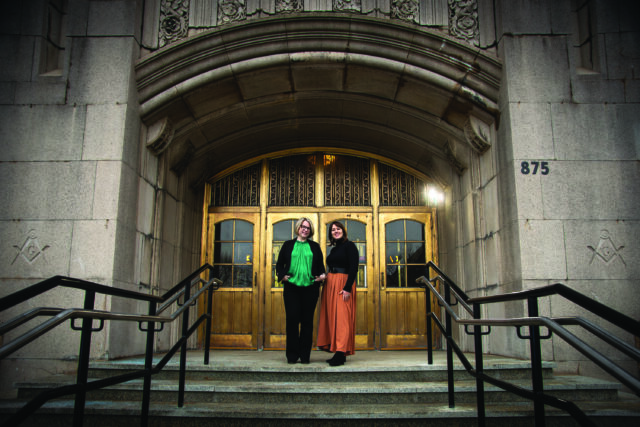 A photograph of Emily Steinbacher and Stephanie Steinman in front of the West Herr Performing Arts Center in Rochester, NY.