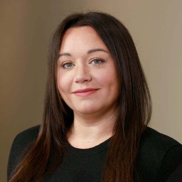 A professional headshot of Dana Adiguzel