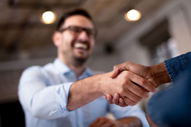 A photograph of two people shaking hands.