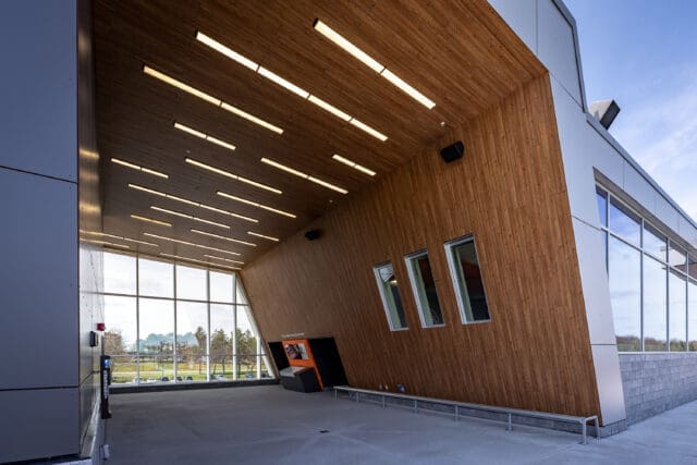 An exterior photograph of RIT's Judson Stadium. The building has a dramatic angular roof and wall with modern lighting.