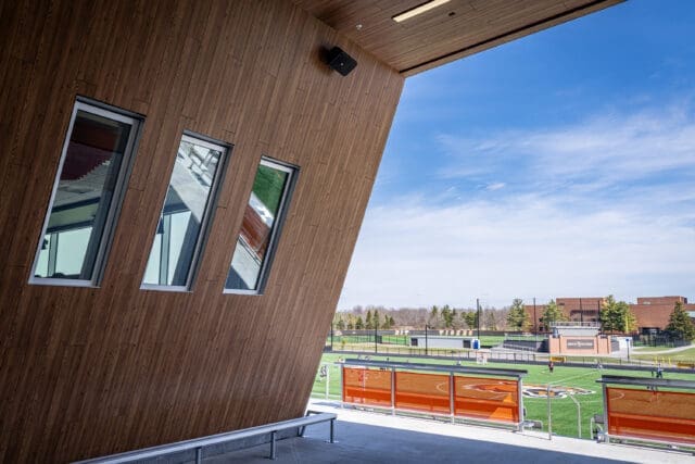 A photograph from under an angular ceiling looking out to a soccer field.