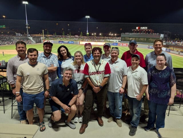 A photograph of a group of people at a baseball stadium