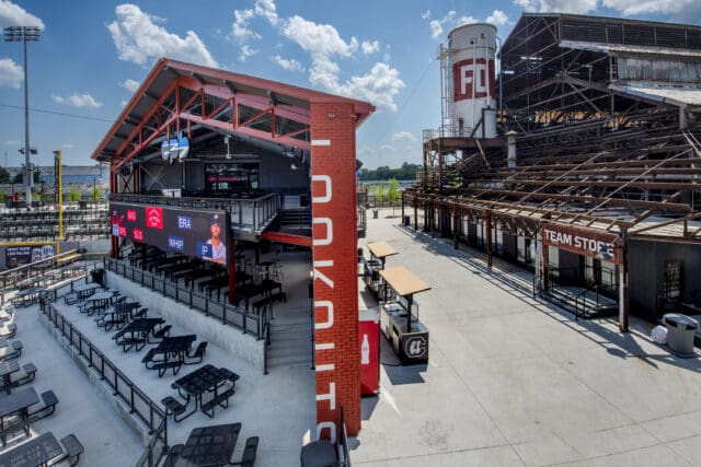 A photograph of a common area within Erlanger Park, a baseball stadium, with an emphasis on old, repurposed structures.