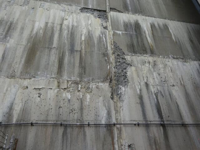 A detail photograph of a dam face in need of repairs.