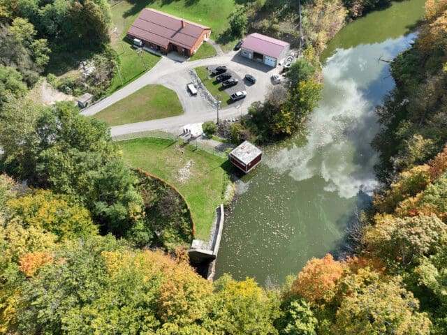 An aerial photograph of Crow Creek in Attica, NY. There are two buildings adjacent to the creek.
