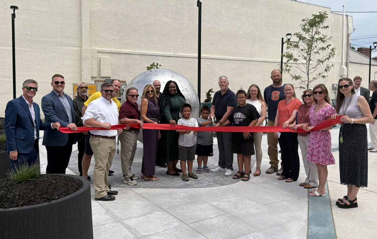 A photograph of a line of people cutting a red ribbon.