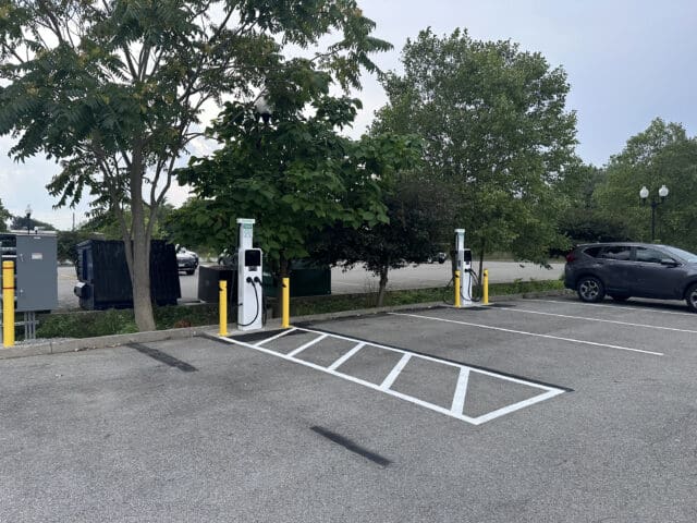A photograph of EV chargers in a parking lot.