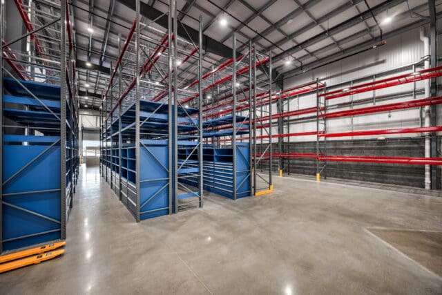 A photograph of a large warehouse space with multiple storage racks.