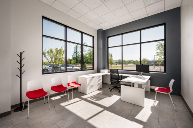 A photograph of an office with ample natural light coming in through multiple windows and modern furniture.