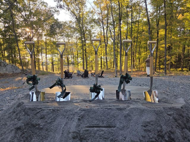 A photograph of five shovels in a pile of direct for a groundbreaking ceremony